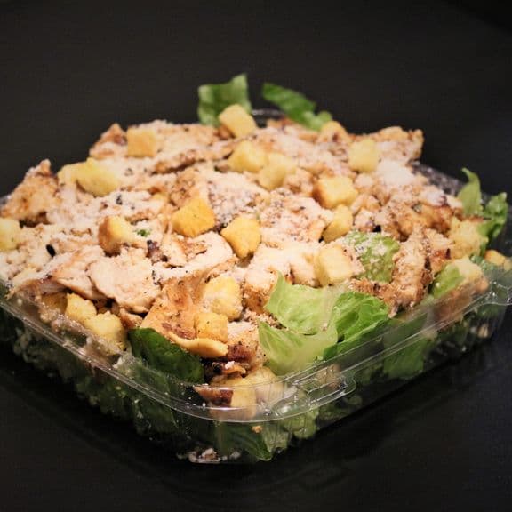 Chicken Caesar Salad - Seasoned grilled chicken breast served over fresh lettuce with crunchy croutons and shaved Parmesan cheese. Accompanied by our creamy Caesar dressing.