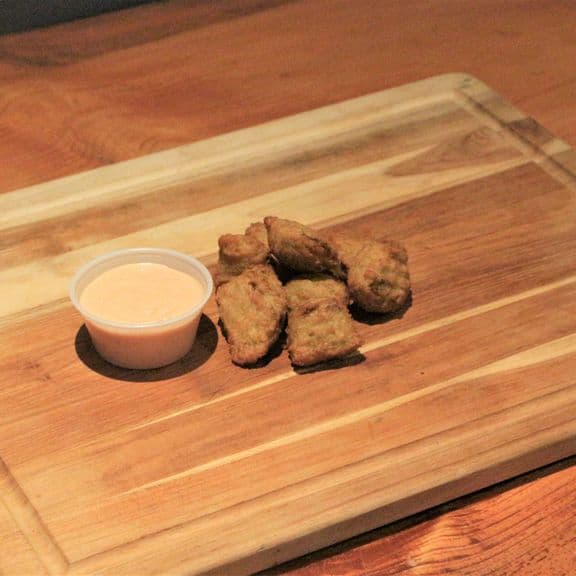 Broccoli Cheese Bites - Eight crispy breaded bites made with fresh broccoli florets and melted cheese. Each bite is seasoned and golden brown, paired with our house-made ranch dipping sauce.