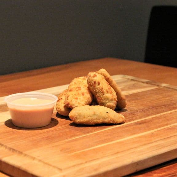 Breaded Jalapenos with Cheddar - Spicy jalapeño peppers stuffed with rich cheddar cheese, coated in a crispy golden breading. Accompanied by our signature Extra Napkin sauce that perfectly balances the heat.